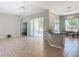 Open living area features tile flooring, gray walls, ceiling fan, and an open floor plan to the kitchen and dining area at 11945 Se 171St Loop, Summerfield, FL 34491