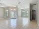Spacious living room featuring tiled floors, a chandelier, and large windows with blinds for natural light at 11945 Se 171St Loop, Summerfield, FL 34491