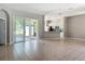 Open living room with tile flooring, view to lanai, and kitchen area complete with modern appliances and white cabinetry at 11945 Se 171St Loop, Summerfield, FL 34491