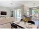 Bright open-concept living room with tile floors, ceiling fan, dining space, and sliding glass doors to screened lanai at 11945 Se 171St Loop, Summerfield, FL 34491