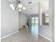 Bright, open-concept living area featuring tile flooring and sliding glass doors leading to a screened patio at 11945 Se 171St Loop, Summerfield, FL 34491