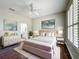 Elegantly furnished main bedroom featuring stylish decor, hardwood floors, and an ensuite bathroom at 11945 Se 171St Loop, Summerfield, FL 34491