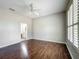 Main bedroom featuring hardwood floors, an ensuite bathroom, and a large window with plantation shutters at 11945 Se 171St Loop, Summerfield, FL 34491