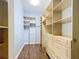 Spacious walk-in closet with custom wooden shelving units and wood floor at 11945 Se 171St Loop, Summerfield, FL 34491