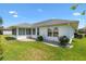 Rear of home boasts an enclosed lanai, well-kept yard, and lovely landscaping at 12147 Se 173Rd Pl, Summerfield, FL 34491