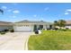Charming single-story home with a well-manicured lawn and clean, white driveway at 12147 Se 173Rd Pl, Summerfield, FL 34491