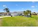 Inviting single-story home with lush green lawn, palms and clean white facade at 12147 Se 173Rd Pl, Summerfield, FL 34491