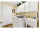 Bright laundry room with modern washer and dryer, utility sink, and storage at 12147 Se 173Rd Pl, Summerfield, FL 34491