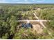 Overhead view of a home with a dark roof surrounded by lush green trees at 12689 Sw 81St St, Dunnellon, FL 34432