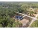 Aerial of a home surrounded by a dense forest with a clear blue sky at 12689 Sw 81St St, Dunnellon, FL 34432