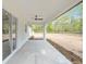 Covered back porch with outdoor ceiling fan overlooking expansive yard and lush, wooded views at 12689 Sw 81St St, Dunnellon, FL 34432