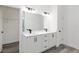 Bathroom showcasing double sink vanity with white cabinets, black hardware, and large mirror at 12689 Sw 81St St, Dunnellon, FL 34432