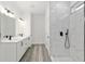 Bright bathroom featuring double sink vanity, a glass enclosed walk-in shower and wood-look flooring at 12689 Sw 81St St, Dunnellon, FL 34432