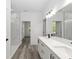Bright bathroom showcasing walk-in shower, double sink vanity and neutral walls with wood-look floors at 12689 Sw 81St St, Dunnellon, FL 34432