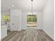 Dining area with views of backyard, modern lighting, and access to kitchen at 12689 Sw 81St St, Dunnellon, FL 34432