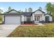 Exterior of a single-story home with a two-car garage, stylish accents, and landscaped yard at 12689 Sw 81St St, Dunnellon, FL 34432