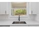 Detailed shot of kitchen sink with stainless steel fixtures and a window overlooking a lush green wooded backyard at 12689 Sw 81St St, Dunnellon, FL 34432