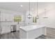 Well-lit kitchen features white cabinets, stainless steel appliances, a large island, and a view to the outdoors at 12689 Sw 81St St, Dunnellon, FL 34432