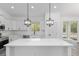 Bright kitchen with white cabinetry, stainless steel appliances, and a large center island featuring stylish pendant lights at 12689 Sw 81St St, Dunnellon, FL 34432