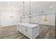 Large open-concept kitchen features a spacious island, modern pendant lights, and luxury vinyl plank flooring throughout at 12689 Sw 81St St, Dunnellon, FL 34432