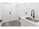 Clean laundry room featuring a stainless steel sink, utility shelving, and gray wood-look floors at 12689 Sw 81St St, Dunnellon, FL 34432