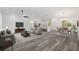 Open-concept living space with stylish furniture, a kitchen island, and modern gray wood flooring at 12689 Sw 81St St, Dunnellon, FL 34432