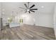 Spacious living room with a modern kitchen, stylish lighting, and attractive gray wood floors at 12689 Sw 81St St, Dunnellon, FL 34432