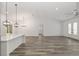 Open floor plan with a kitchen island, dining area, and inviting gray wood flooring at 12689 Sw 81St St, Dunnellon, FL 34432