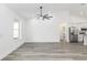 Bright and spacious living room featuring a modern ceiling fan and gray wood flooring at 12689 Sw 81St St, Dunnellon, FL 34432