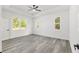 A spacious main bedroom with tray ceilings, large windows providing natural light, and stylish luxury vinyl plank flooring at 12689 Sw 81St St, Dunnellon, FL 34432