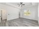 Bright main bedroom with wood-look flooring, neutral walls, ceiling fan and a view to the outdoors at 12689 Sw 81St St, Dunnellon, FL 34432