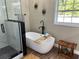 Luxurious bathroom with standalone tub, walk-in shower, and modern black fixtures at 13430 Ne 30Th Ct, Anthony, FL 32617