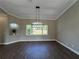 Bright dining area with hardwood floors, a modern light fixture, and a large window, perfect for gatherings at 13430 Ne 30Th Ct, Anthony, FL 32617