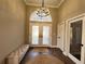 Elegant foyer with a modern chandelier and glass double doors, creating a bright and welcoming entry at 13430 Ne 30Th Ct, Anthony, FL 32617