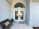 Inviting front porch with double doors, a cozy bench, and a 'welcome' sign, creating a warm entrance at 13430 Ne 30Th Ct, Anthony, FL 32617