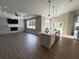 Spacious living room with fireplace, large windows, and open layout to kitchen and dining areas at 13430 Ne 30Th Ct, Anthony, FL 32617