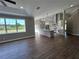 Open-concept living space with a large kitchen island, hardwood floors, and plenty of natural light at 13430 Ne 30Th Ct, Anthony, FL 32617