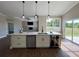 Modern kitchen island with white cabinets, quartz countertop, and wine fridge, perfect for entertaining at 13430 Ne 30Th Ct, Anthony, FL 32617