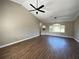 Spacious living room featuring hardwood floors, a ceiling fan, and ample natural light, creating a comfortable living space at 13430 Ne 30Th Ct, Anthony, FL 32617