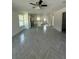 Open-concept living area featuring stylish herringbone floors, ample natural light, and modern ceiling fan at 14173 Se 41St Ter, Summerfield, FL 34491