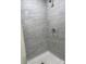 Walk-in shower featuring neutral tile and modern fixtures with a shower head and handheld wand at 14173 Se 41St Ter, Summerfield, FL 34491
