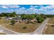 Aerial view of a home with a spacious lawn, mature trees, and neighboring properties in a residential area at 14555 Se 98Th Ave, Summerfield, FL 34491