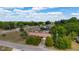 Aerial view of a single-story home with a well-maintained lawn and mature trees at 14555 Se 98Th Ave, Summerfield, FL 34491