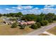 An aerial view of a single-story home, featuring a lush yard, mature trees, and a metal roof at 14555 Se 98Th Ave, Summerfield, FL 34491