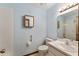 Bright bathroom featuring blue walls, vanity, lighting, mirror, toilet, and shower-tub combo at 14555 Se 98Th Ave, Summerfield, FL 34491