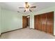 The light-filled bedroom includes a ceiling fan and a closet with louvered doors at 14555 Se 98Th Ave, Summerfield, FL 34491