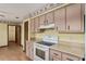 A quaint kitchen featuring wood floors, light wood cabinets, and an oven at 14555 Se 98Th Ave, Summerfield, FL 34491