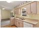 Charming kitchen with light wood cabinets, and a double sink beneath the window at 14555 Se 98Th Ave, Summerfield, FL 34491