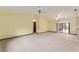 Large living room with vaulted ceilings, ceiling fans, neutral carpet, and a sliding glass door to the backyard at 14555 Se 98Th Ave, Summerfield, FL 34491