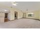 Large living room showcasing neutral carpet, ceiling fans, and an open layout to the kitchen, ideal for Gathering gatherings at 14555 Se 98Th Ave, Summerfield, FL 34491